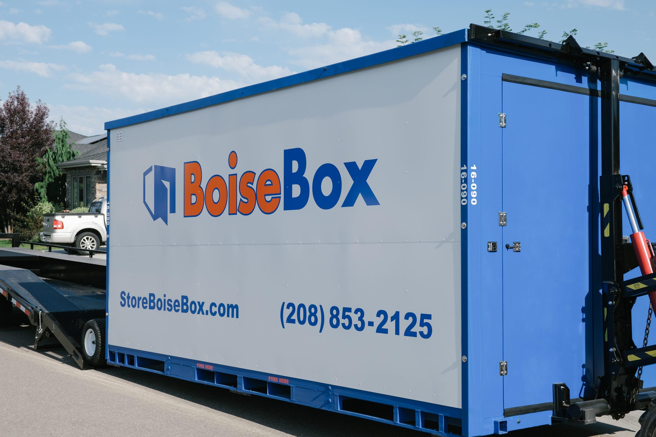 Customer carrying boxes beside an open BoiseBox container